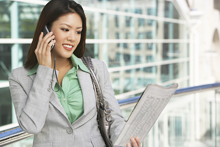 woman with cell phone and newsletter